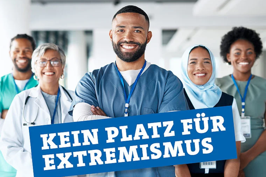 Fünf medizinische Fachkräfte verschiedener Herkunft lächeln, Text 'Kein Platz für Extremismus' im Vordergrund