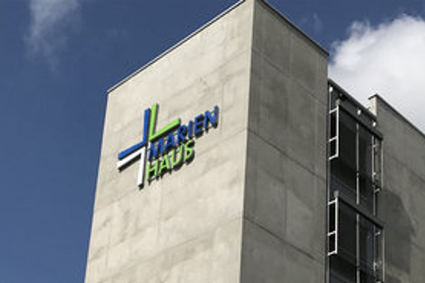 Eingang des Marienhaus Klinikums Mainz mit sichtbarem Gebäudeturm und blauem Himmel mit Wolken
