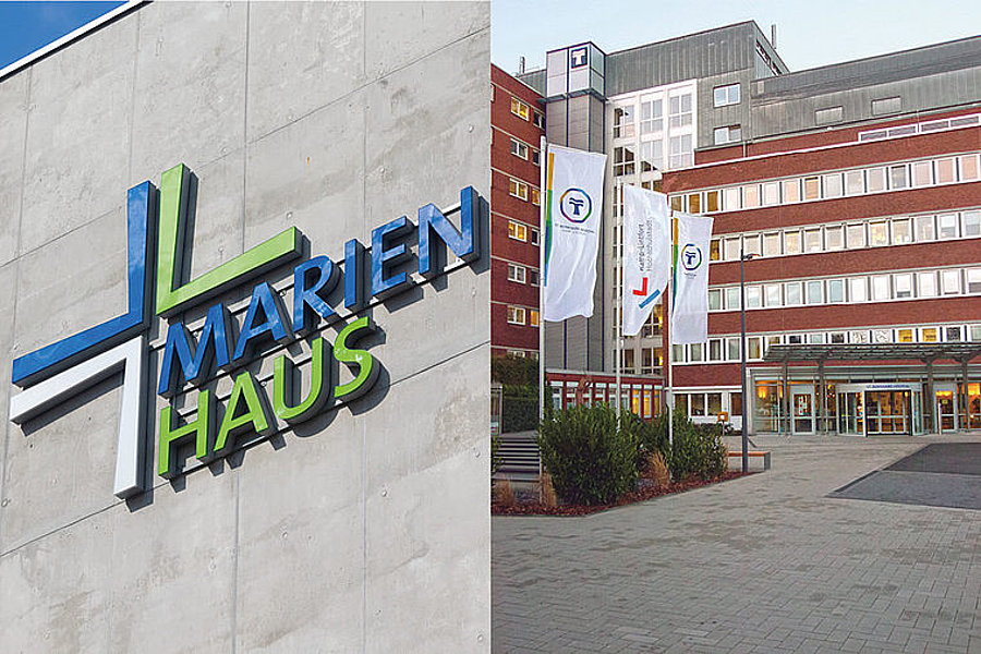 Außenansicht des Marienhaus Krankenhauses mit Logo an der Wand und Eingangsbereich mit Fahnen