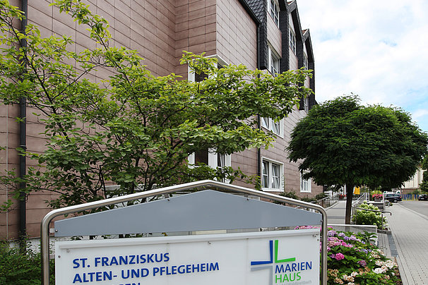 Außenansicht des St. Franziskus Alten- und Pflegeheims Dillingen mit einem Schild, das 'Herzlich willkommen!' und das Marienhaus Logo zeigt.