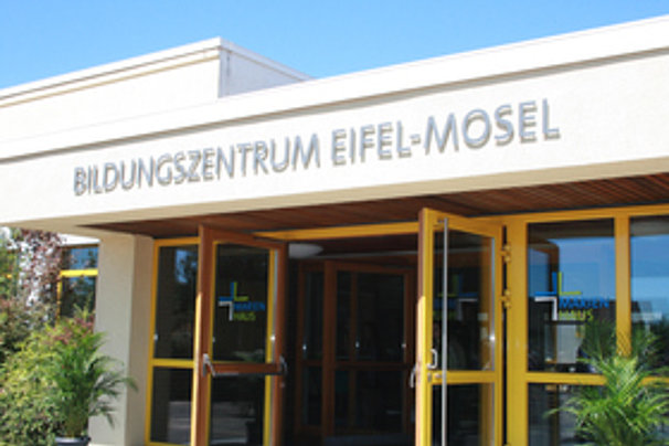 Eingang des Bildungszentrums Eifel-Mosel mit Glas- und Holztüren und Schriftzug über dem Eingang