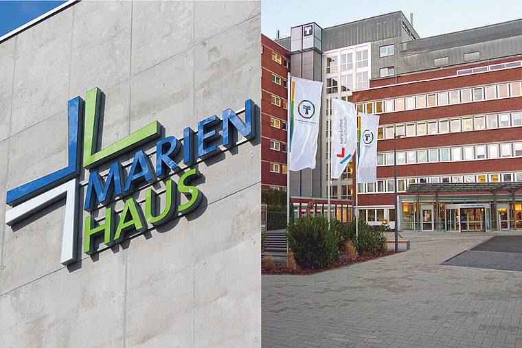 Außenansicht des Marienhaus Krankenhauses mit Logo an der Wand und Eingangsbereich mit Fahnen