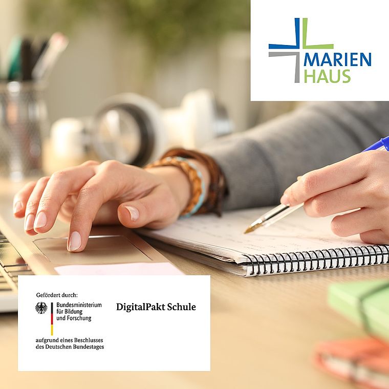 Person schreibt mit blauem Stift in Spiralnotizbuch, daneben Logo Marienhaus und Hinweis auf Förderung durch DigitalPakt Schule des Bundesministeriums für Bildung und Forschung